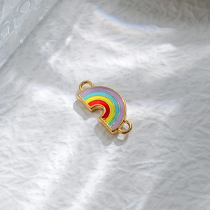 Rainbow acrylic pendant with gold plating on a white textured background