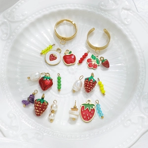 DIY sieradenset met aardbei appel emaille hangers parels en kralen op wit dienblad