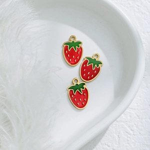 Detailweergave van drie rode aardbeienbedels met goud voor DIY-sieraden maken