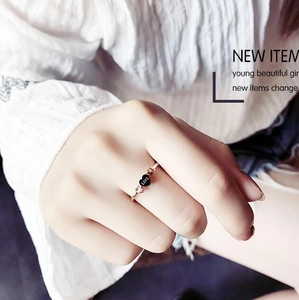 Detail of rose gold love heart ring featuring a black heart charm and sparkling zircon