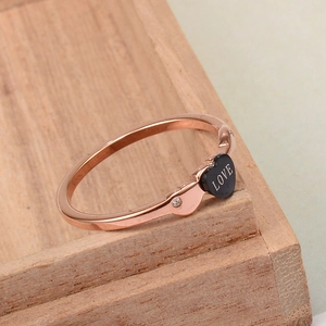 Close-up of rose gold Love ring with black heart charm and tiny sparkling zircon