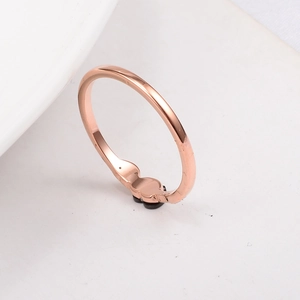 Detailed macro view of a rose gold titanium ring featuring a black clover leaf motif