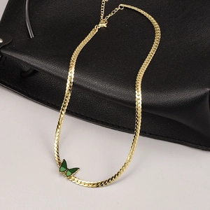 Collier vintage doré avec pendentif papillon vert sur fond de cuir noir élégant