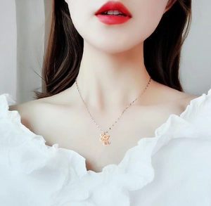 Collier avec pendentif rat du zodiaque or rose porté par un mannequin au cou