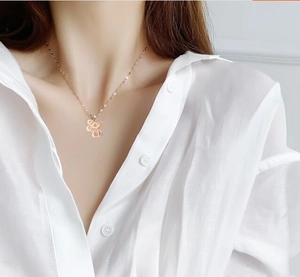 Collier avec pendentif rat du zodiaque en or rose porté sur le cou d'un mannequin