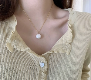 Detail view of 18K gold plated titanium steel necklace with freshwater pearl pendant
