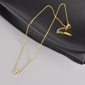 Minimalist 18K gold necklace with a delicate four-petal flower pendant and lobster clasp