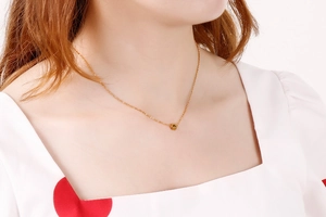 Elegante collana d'oro con ciondolo a zampa di gatto su modella in stile casual