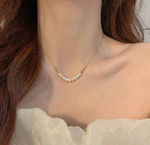 Detailansicht der Süßwasserperlen-Halskette am Schlüsselbein des Models mit Goldkette