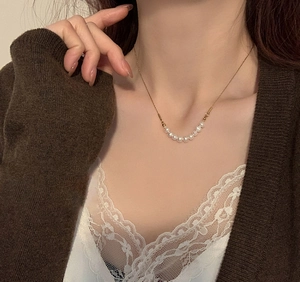Elegante Halskette mit echten Süßwasserperlen an einer feinen Goldkette auf Spitzen-Top