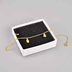 18K gold-plated calabash anklet with engraved lucky pendant on a white jewelry box