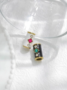 Detailed macro view of black and white enamel beads with colored diamond inlays