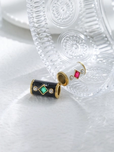Detail of gold-rimmed black and white enamel barrel beads with inlaid gemstones