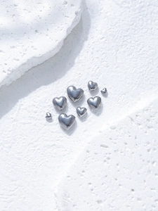 Detailed view of silver heart-shaped stainless steel beads for DIY jewelry making
