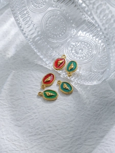 Detail of 18K gold shell charms with red and green enamel for DIY jewelry making