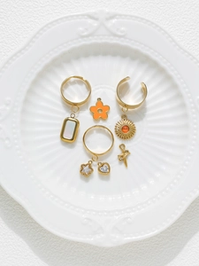 Detailed macro view of gold-plated charms featuring stars, hearts, and sun with cubic zirconia