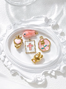 Detailed view of pink enamel charms including heart, bunny, and fish for DIY jewelry