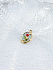 Détail du pendentif tulipe ovale avec cadre doré et émail rouge sur fond blanc
