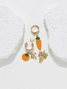 Macro view of gold fruit pendants including carrot, persimmon and grape for DIY jewelry