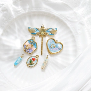 Kit de breloques bijoux DIY avec libellules dorées et motifs floraux sur plateau blanc