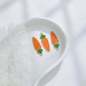 Three carrot-shaped pendants with green leaves and gold edges for DIY jewelry making