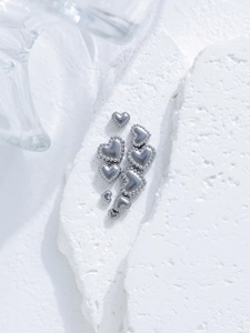 Macro shot of heart-shaped stainless steel beads with beaded edges for DIY jewelry making