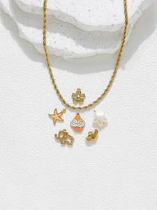 Détail d'un collier chaîne torsadée dorée avec divers pendentifs comme cupcake et éléphant