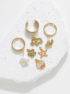 Détail de breloques DIY colorées incluant étoiles de mer et cupcakes sur base pierre