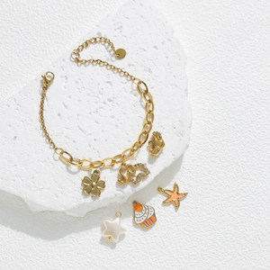 Bracelet à breloques en acier doré avec étoile de mer et éléphant sur pierre blanche