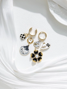 Detail of vintage enamel charms including flower bag and hat with gold rings