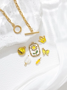 Gold stainless steel toggle necklace with butterfly and basketball charms on silk