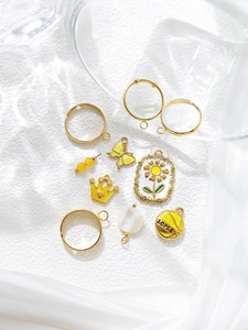 Detail view of gold butterfly crown charms and floral pendants for DIY jewelry making