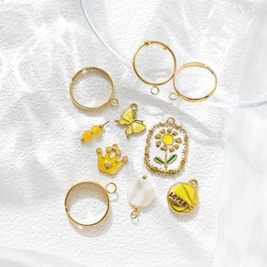 DIY jewelry charm set with golden butterfly crown and basketball pendants on white fabric