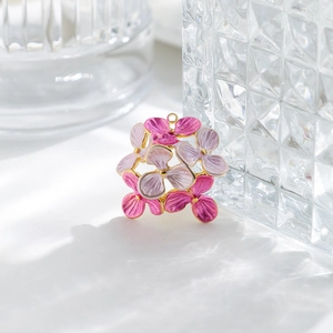 Detail of pink and purple enamel flower charms with gold edges for jewelry making
