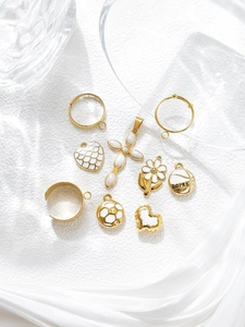 Macro shot of gold-plated heart and daisy enamel charms for DIY jewelry making