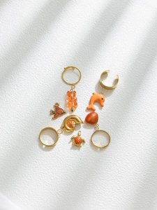 Detailed view of gold ocean-themed pendants with colorful enamel fish and dolphin charms