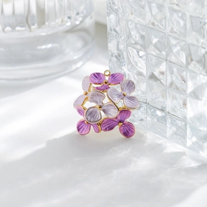 Close-up of purple enamel flower pendant with golden metal edges and hanging loop
