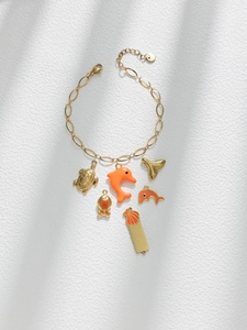 Close-up of gold S925 sterling silver ocean charms bracelet with orange enamel details