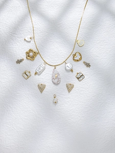 Detail einer böhmischen Goldkette mit Anhängern wie Herz, Blume und Perlenbesatz