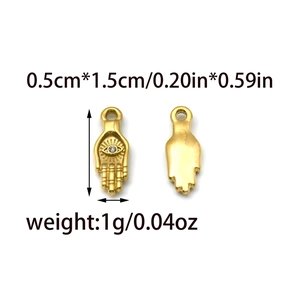 Detailed view of 1.5cm golden Hamsa pendant with eye pattern and crystal inlay