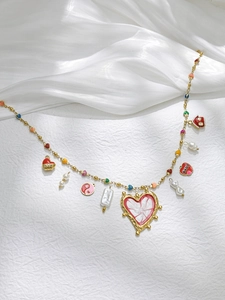 Detail of 18K gold-plated beaded necklace with red enamel heart and house pendants