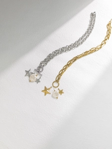 Detalle de colgantes de estrella en oro 18K y plata con perlas barrocas en cadenas OT