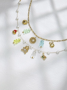 Detail of paperclip and pearl necklaces with gummy bear, rabbit and heart charms