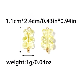 Detail showing two yellow gummy bear pendants with gold loops and size measurement marks