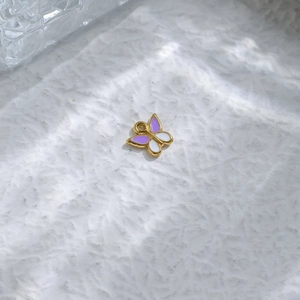 Detail of purple and white enamel butterfly charm pendant in gold finish for DIY crafts