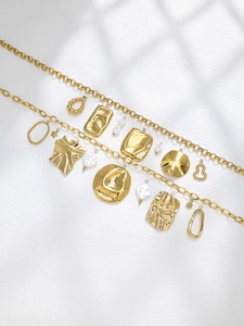 Macro detail of 18K gold stainless steel geometric charms and shell pendants