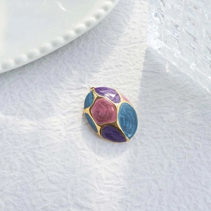 Macro shot of French vintage enamel flower pendant with purple and blue swirl texture