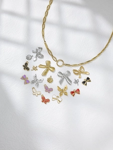 Detailed macro view of gold chain and colorful enamel butterfly pendants on white background