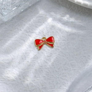 Detail of red enamel bow pendant with gold plating and ring for DIY jewelry making