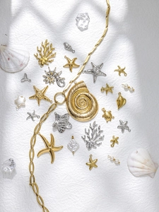 Flat lay of ocean-themed 304 stainless steel sea turtle and starfish pendants